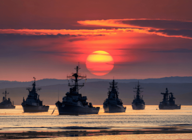Military ships at sunset